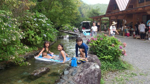 魚つかみ取りの出来る小川で遊ぶ子供たち